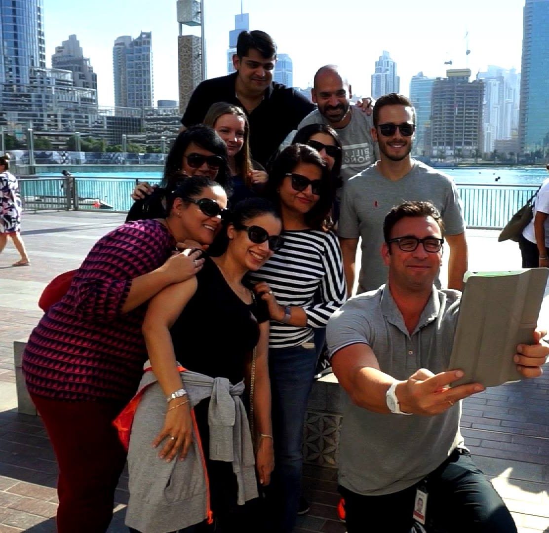 A team on an Urban Game in Dubai, taking a selfie with the tablet by the water