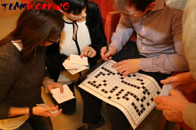 A team filling in a giant crossword together