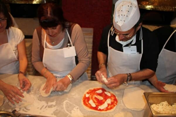 A team making pizza with a master pizzaiolo, from the dough to the oven