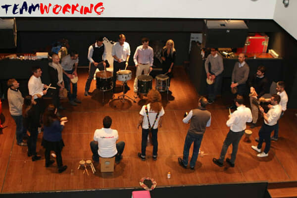 A group playing percussion together in a circle