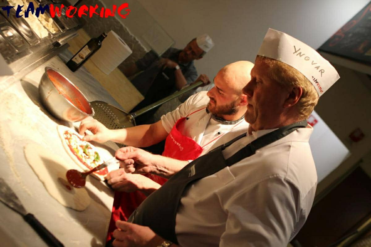 A team making pizza with a master pizzaiolo, from the dough to the oven