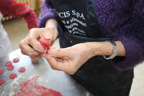 A team decorating a cake with sugar paste during a Cake Design activity