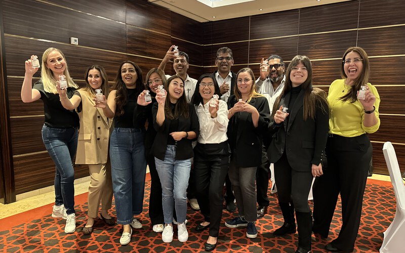 A team holding up the perfumes they created together