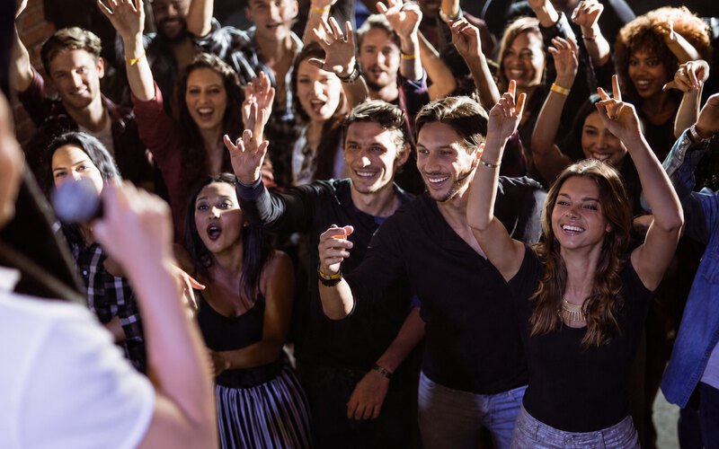 A group laughing together with arms raised during a Laughter Yoga session