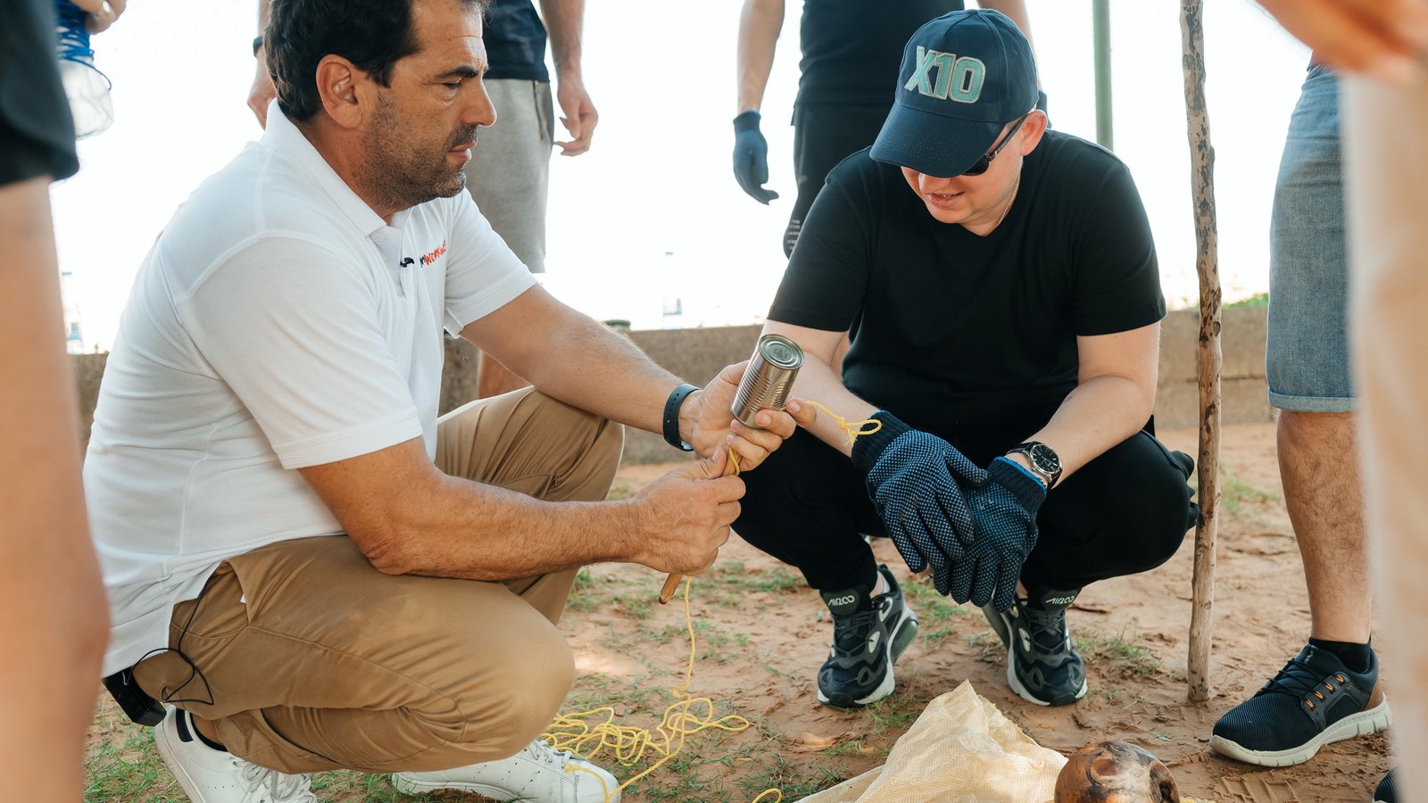 A trainer and a participant preparing the tinder in the desert during outdoor training