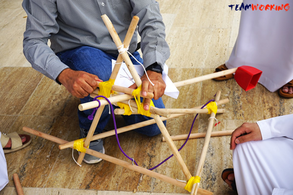 A team cutting and sewing an outfit by hand