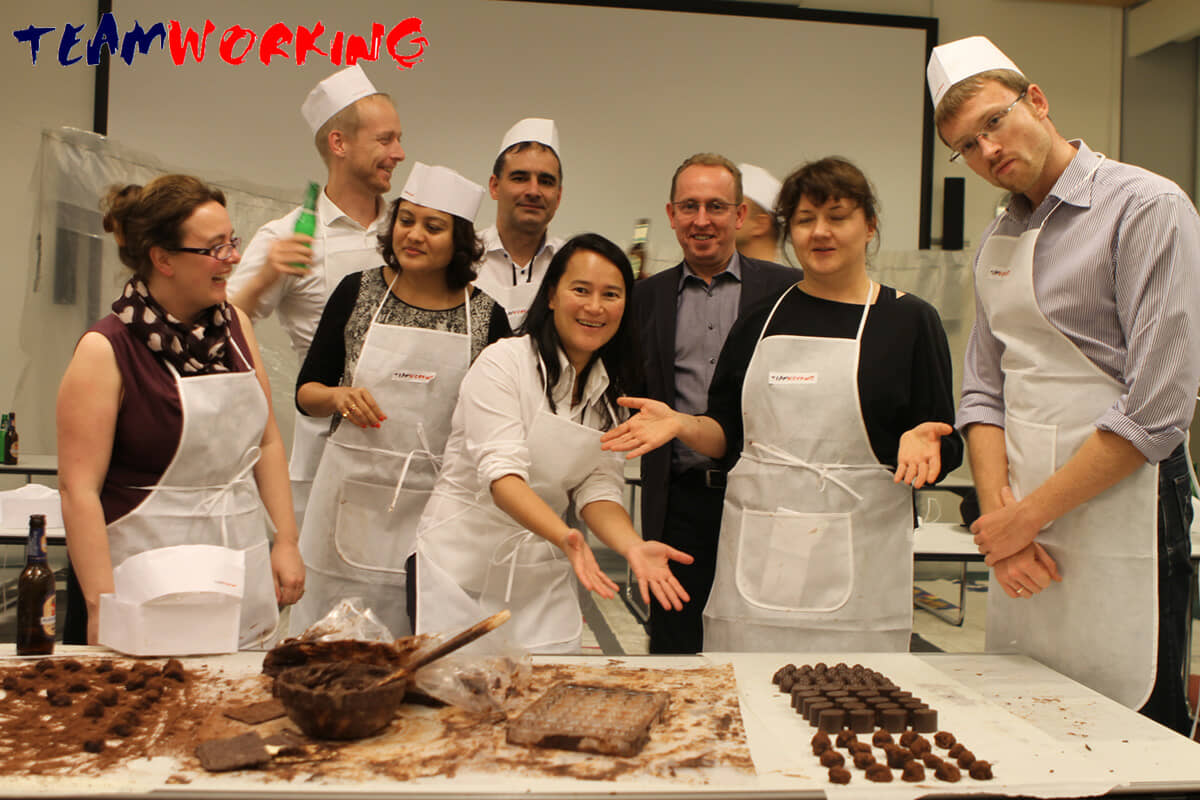 Hands shaping and decorating chocolates during a Choco Making activity