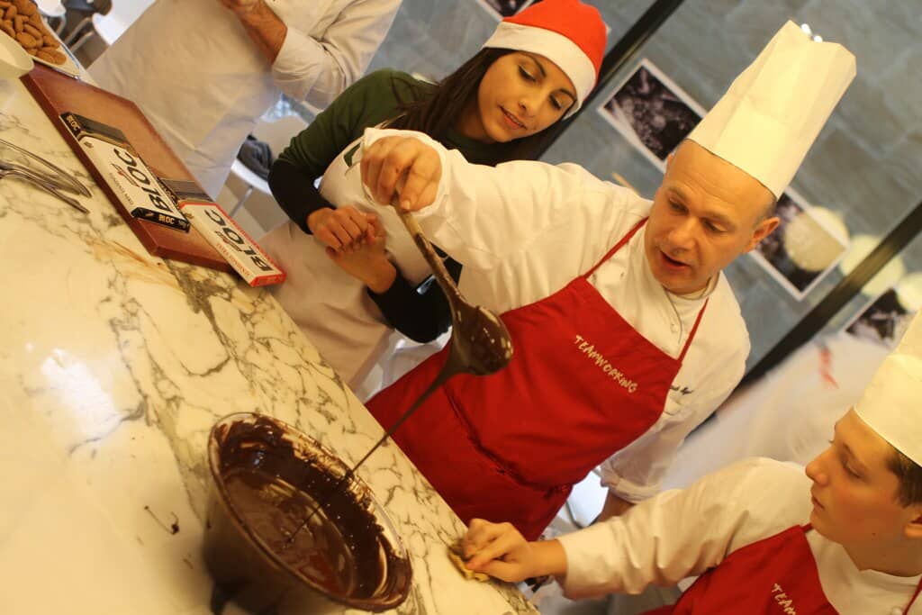 Hands shaping and decorating chocolates during a Choco Making activity