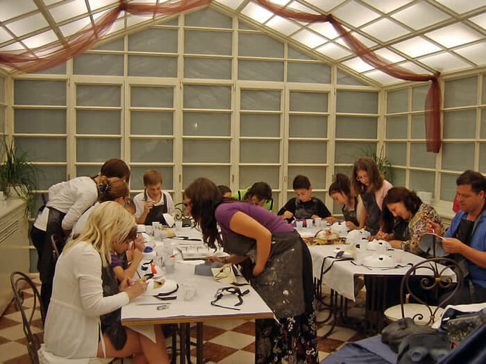 A team cutting and sewing an outfit by hand