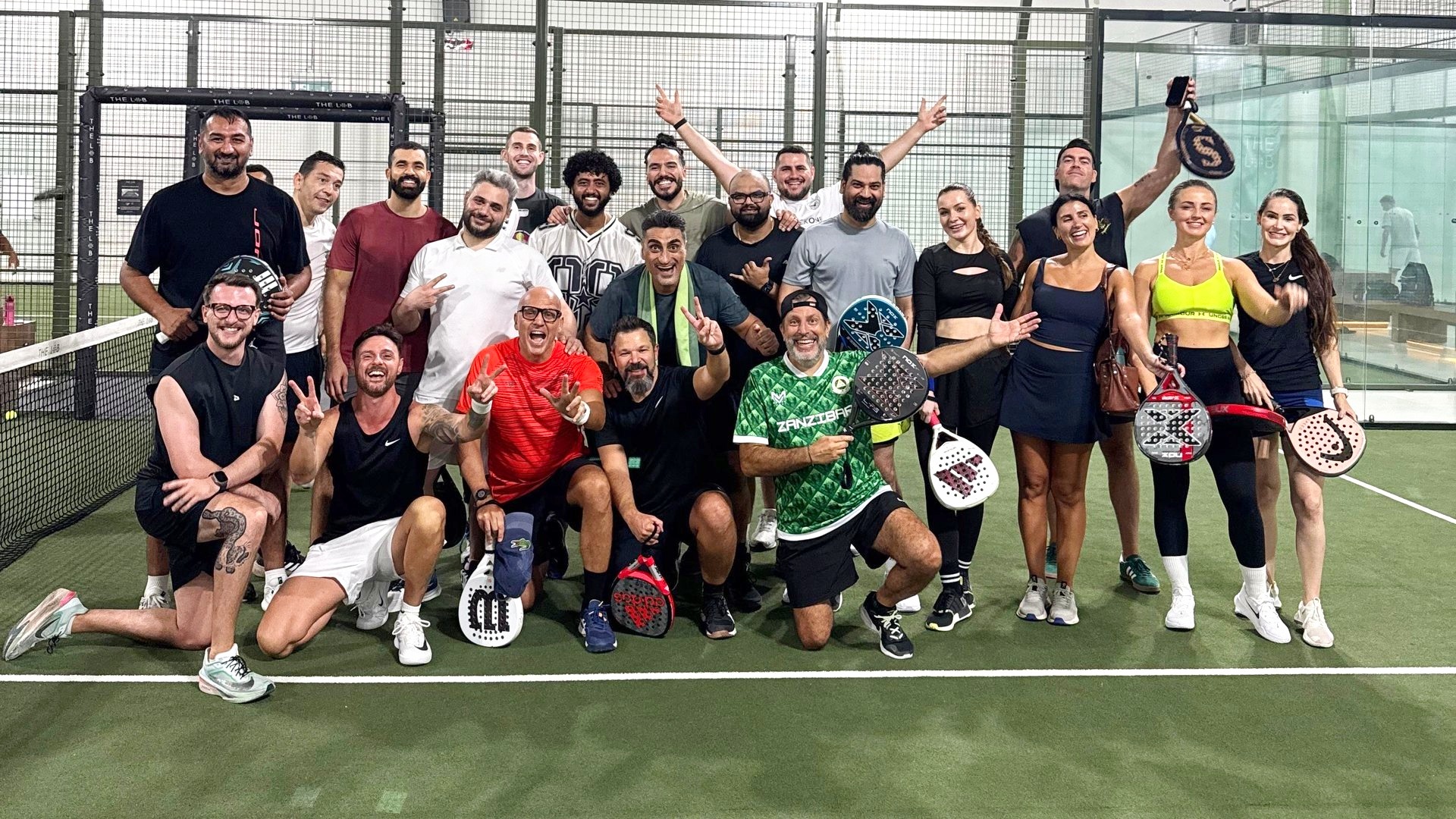 Teams on a padel court with a coach watching from the side