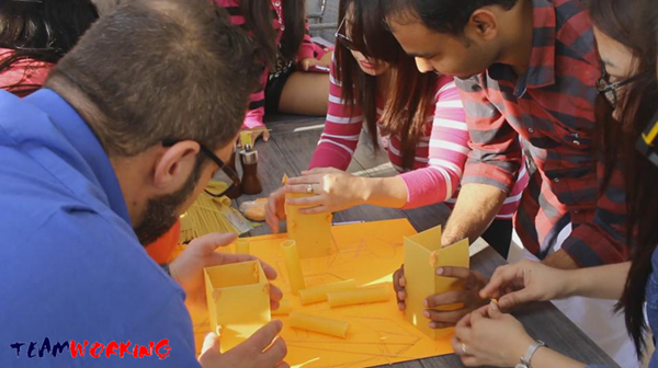 Colleagues making fresh pasta by hand at a work table
