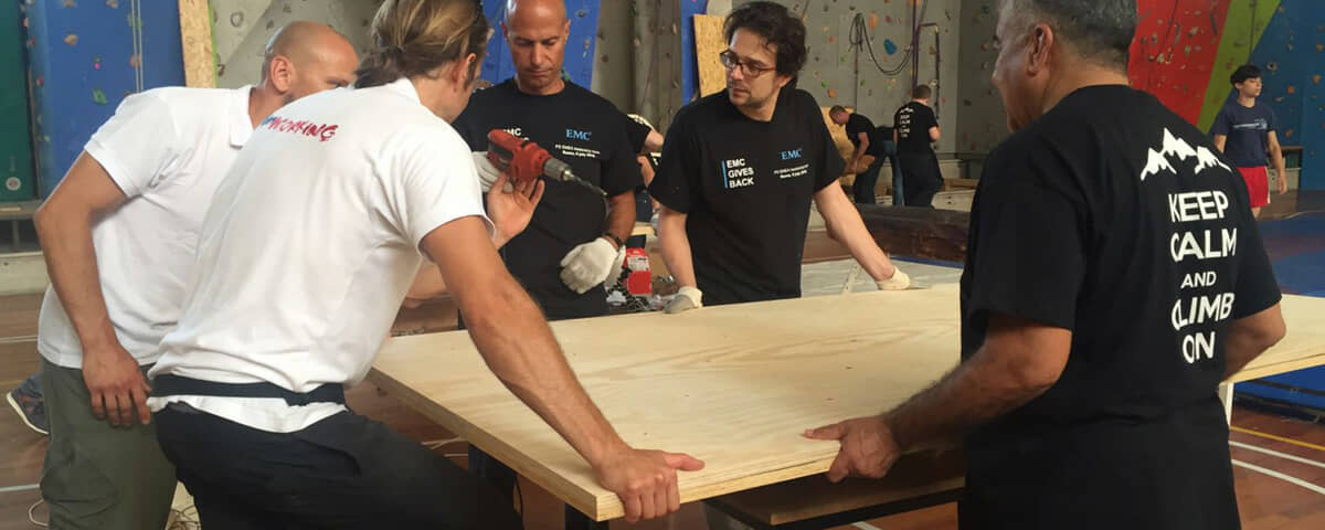 A team building something with real tools for a school or a community