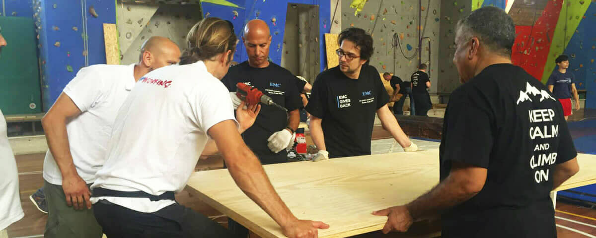 A team building something with real tools for a school or a community