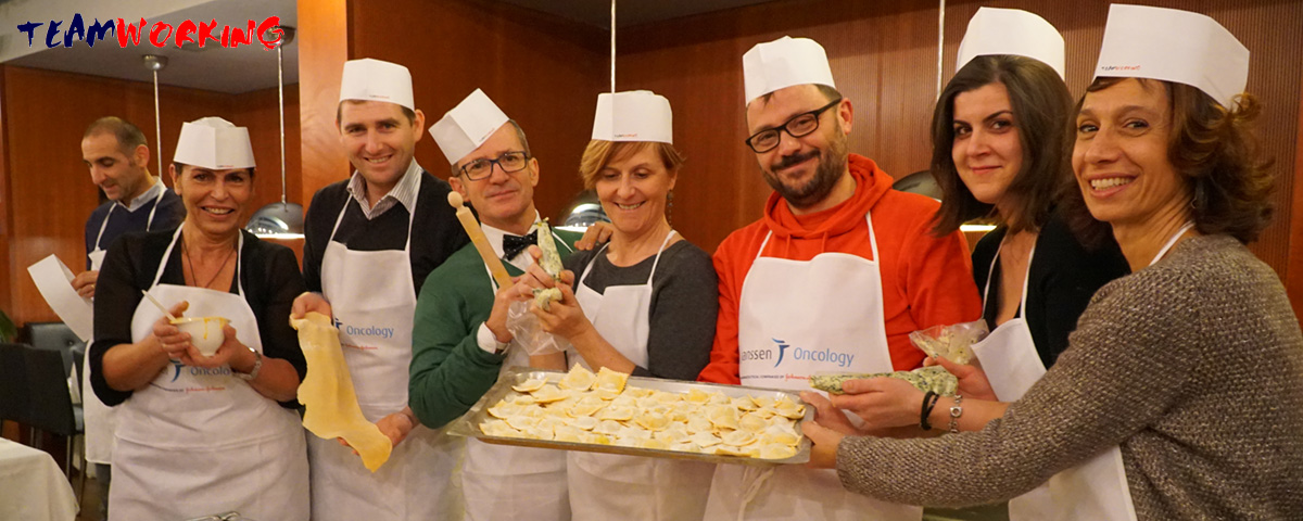 Colleagues making fresh pasta by hand at a work table